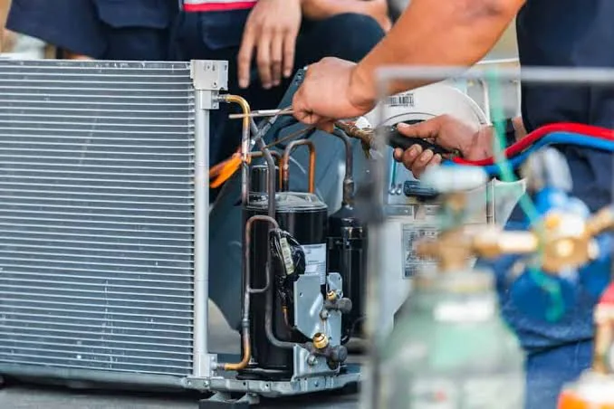 Close-up of a technician repairing air conditioning components