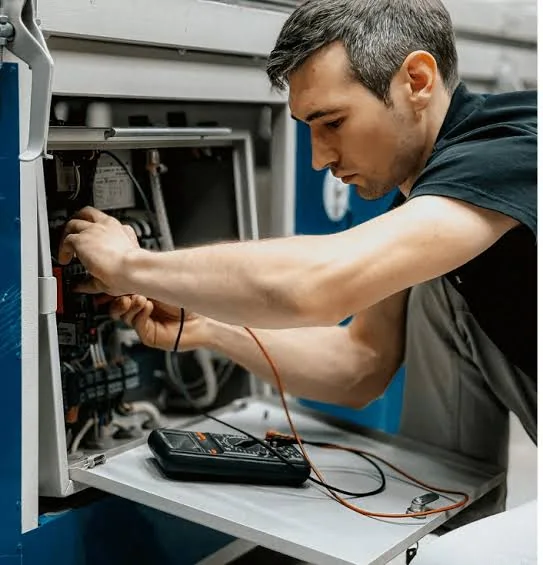 Technician diagnosing controls inside HVAC equipment