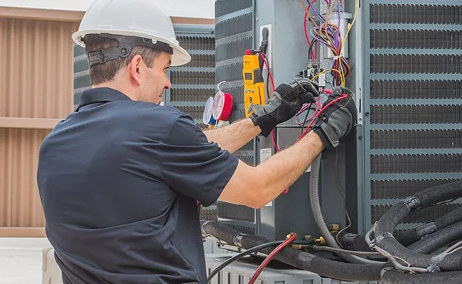 HVAC technician testing an outdoor residential air conditioning system