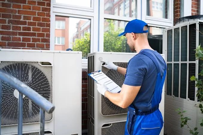 HVAC technician inspecting outdoor comfort equipment with a service checklist