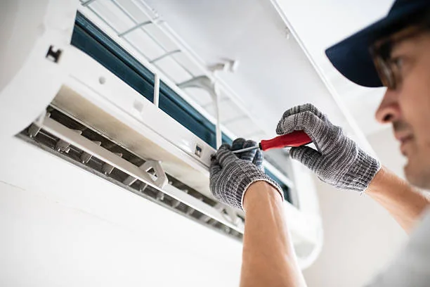 Technician completing a precision repair on an indoor air conditioning unit